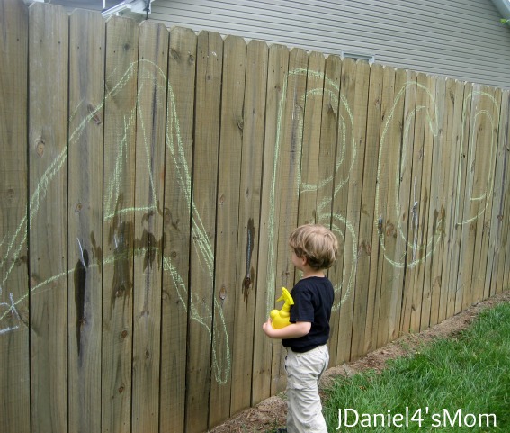 Drawing with Chalk on a Fence