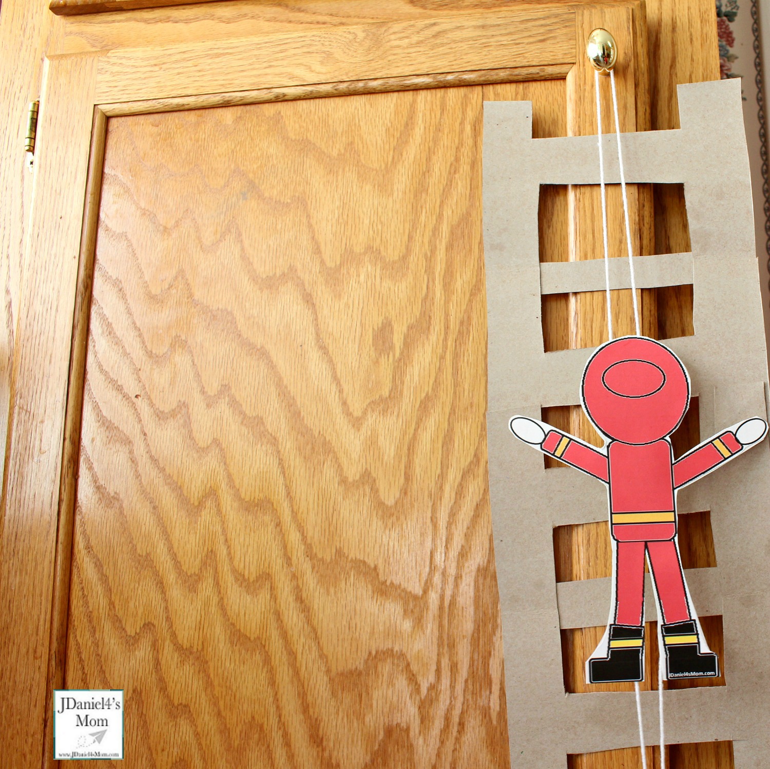 Climbing Firefighter STEAM Activity for Kids - Attached to the Cabinet Knob